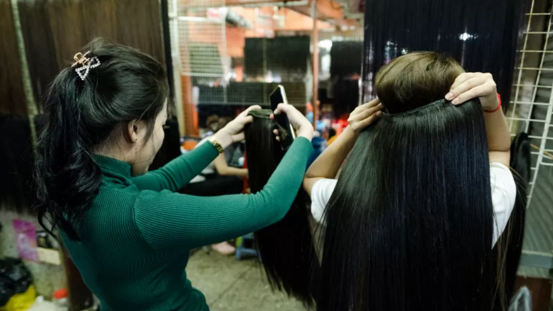 A Woman In Cambodia Is Checking Hair Extensions